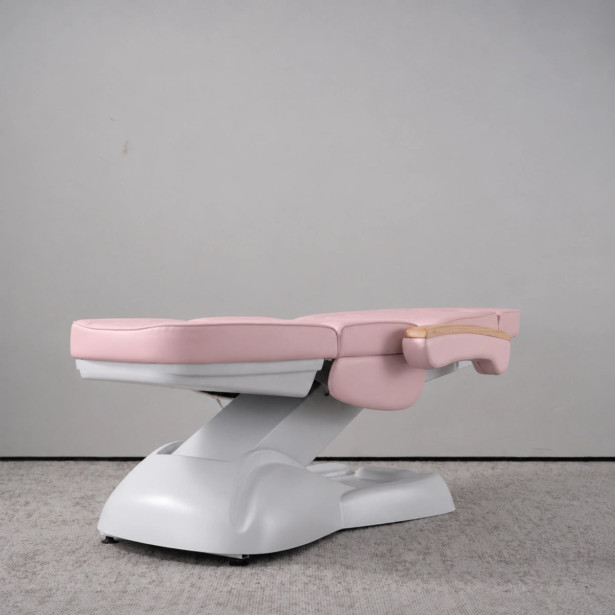 Manufakturo Grace Bare Blush electric beauty bed lying flat, with wooden armrest caps and the original white inclined lift and sculpted base.