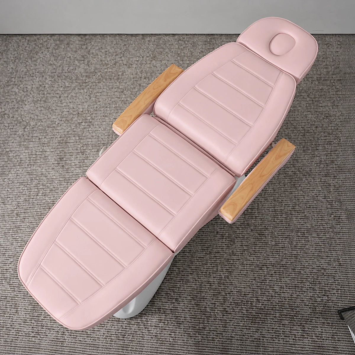 Manufakturo Grace Bare Blush electric beauty bed viewed from above, showing the segmented upholstery, face insert and wooden armrest caps.