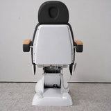 Rear view of the Manufakturo Grace Black electric beauty bed, showing the upholstered headrest, white rigid rear cover and adjustment mechanism.
