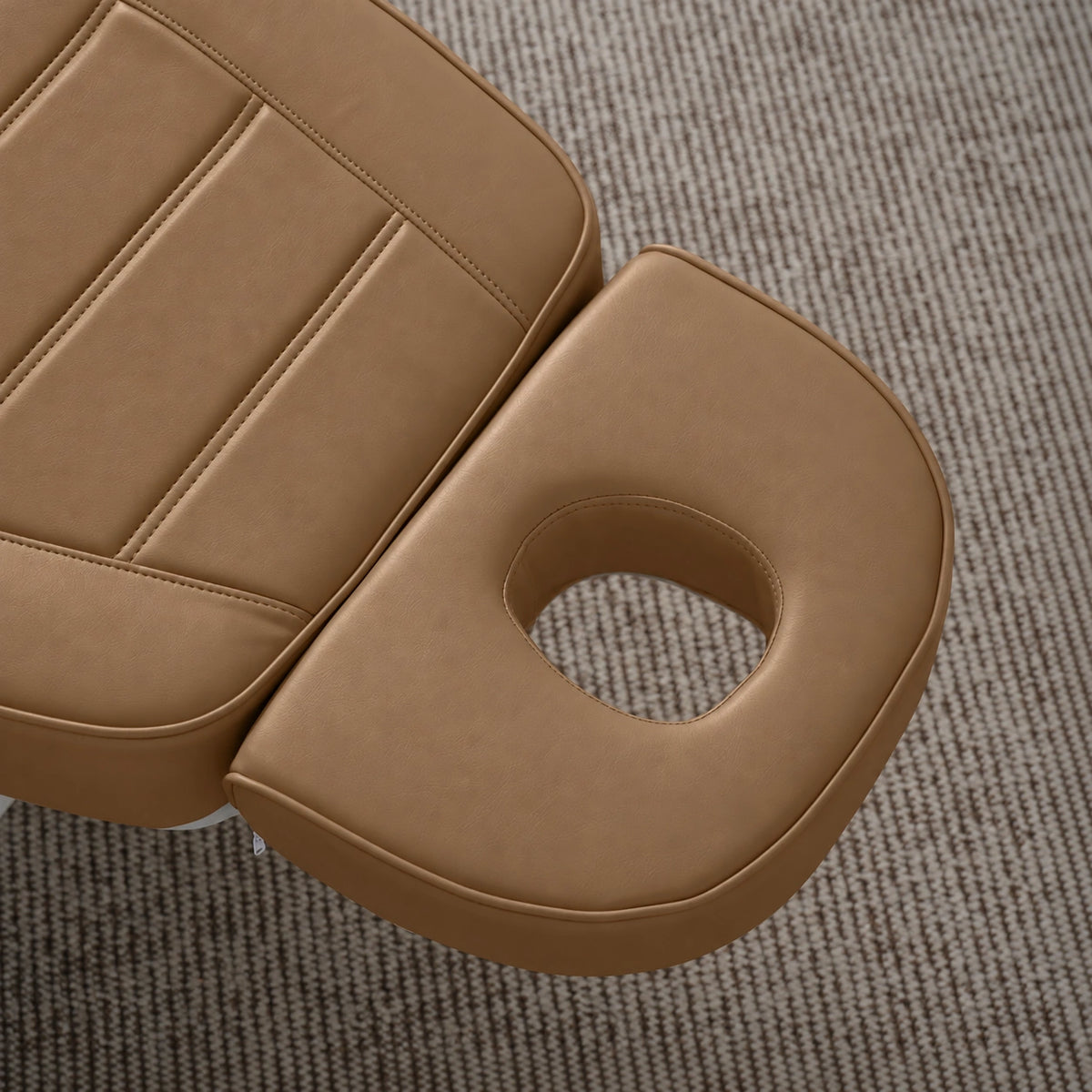 Manufakturo Grace Caramel electric beauty bed headrest detail, showing the open massage face hole and matching stitched upholstery.