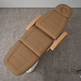 Manufakturo Grace Caramel electric beauty bed viewed from above, showing the segmented upholstery, face insert and wooden armrest caps.