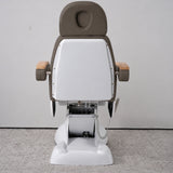 Rear view of the Manufakturo Grace Cocoa Mocha electric beauty bed, showing the upholstered headrest, white rigid rear cover and adjustment mechanism.