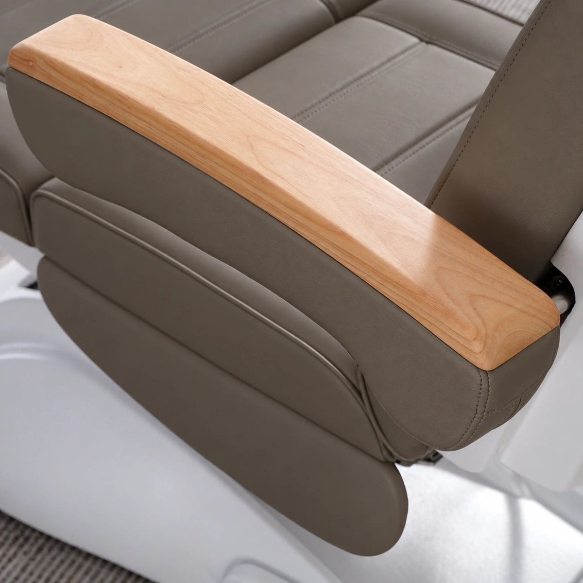 Manufakturo Grace Cocoa Mocha electric beauty bed armrest detail, showing the natural wooden top and matching upholstered side cushions.