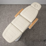 Manufakturo Grace Creamy electric beauty bed viewed from above, showing the segmented upholstery, face insert and wooden armrest caps.