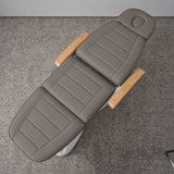 Manufakturo Grace Deep Ash electric beauty bed viewed from above, showing the segmented upholstery, face insert and wooden armrest caps.