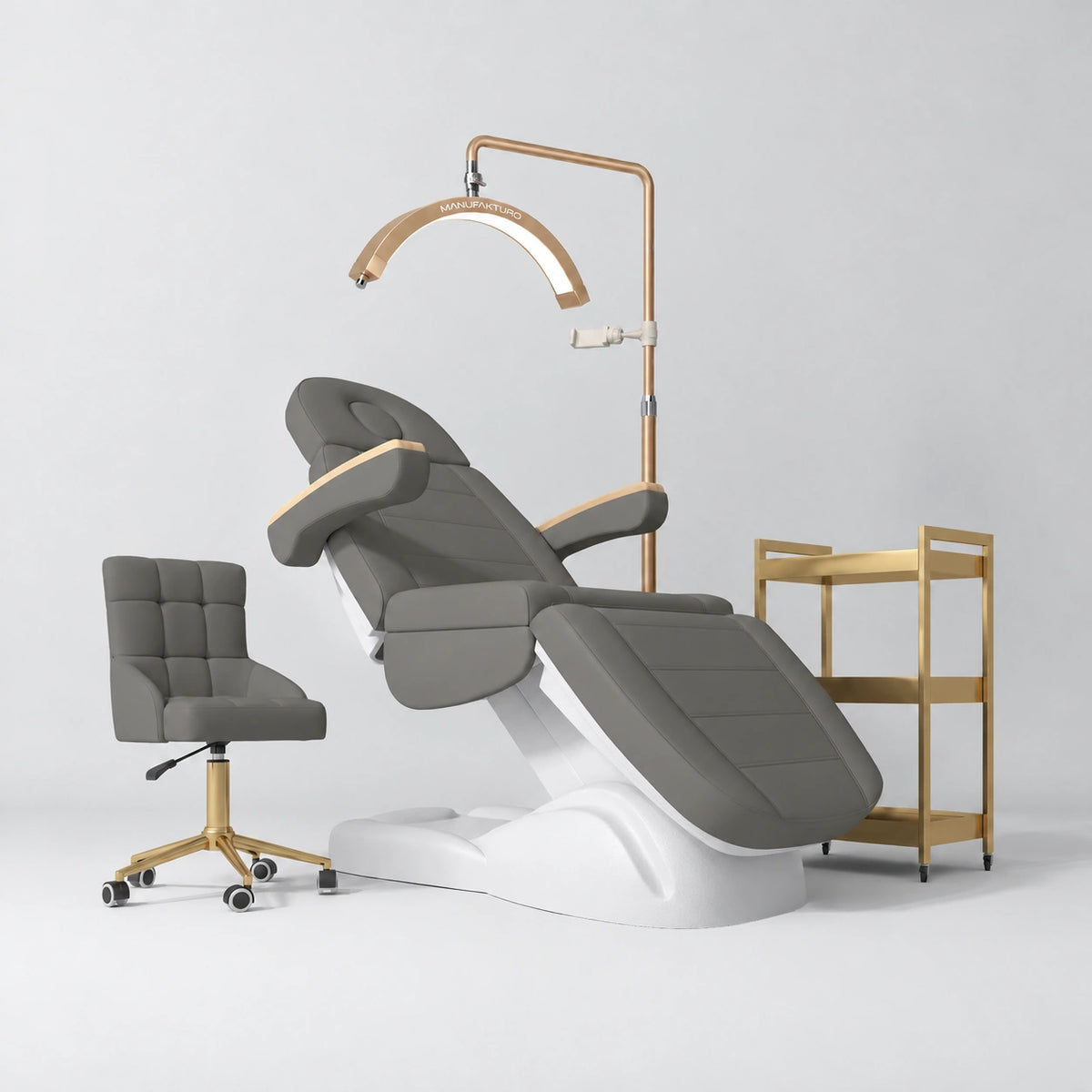 Manufakturo Grace Deep Ash complete salon set with electric beauty bed, Noblesse chair, V3 Pro Gold treatment lamp and three-tier gold trolley.