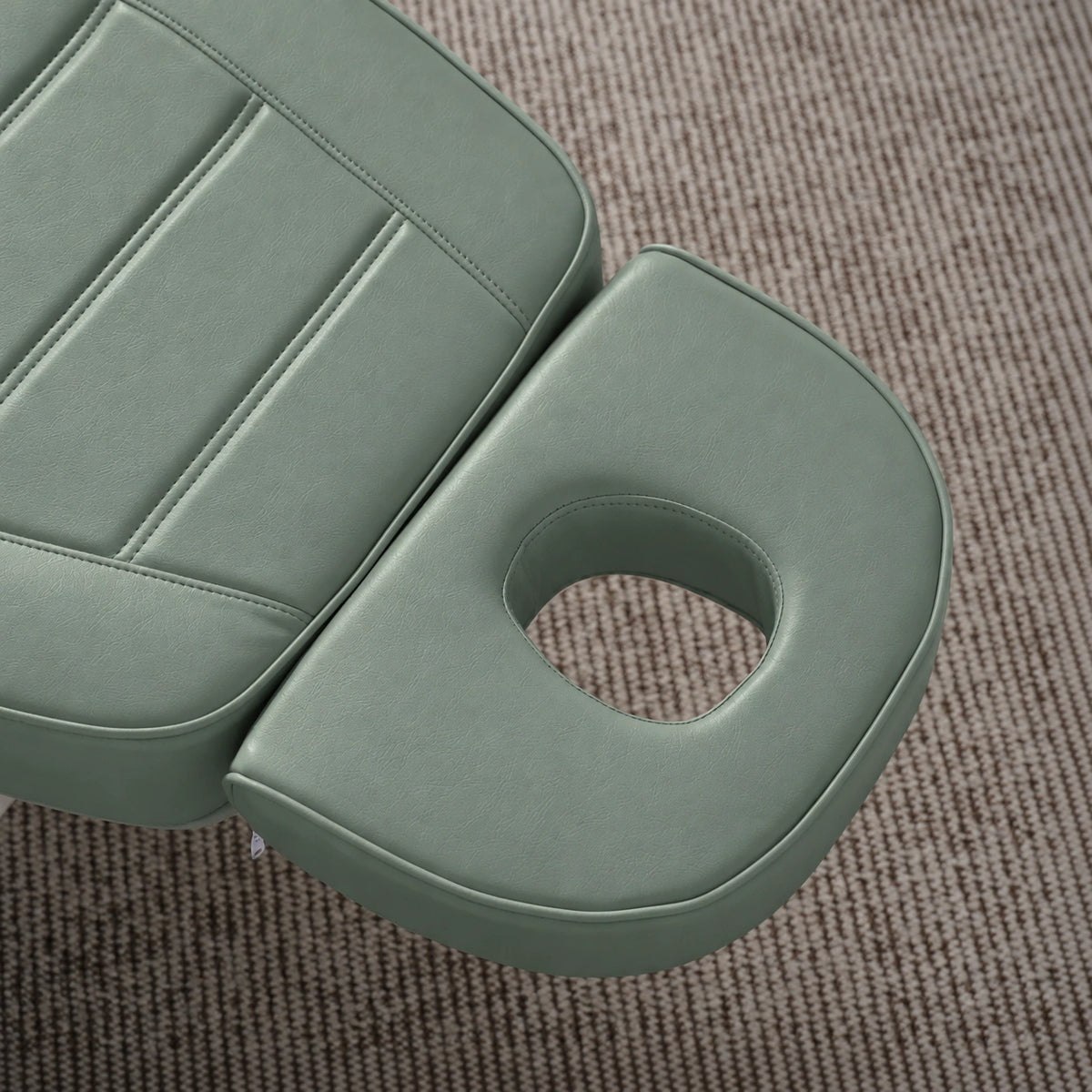 Manufakturo Grace Olive electric beauty bed headrest detail, showing the open massage face hole and matching stitched upholstery.