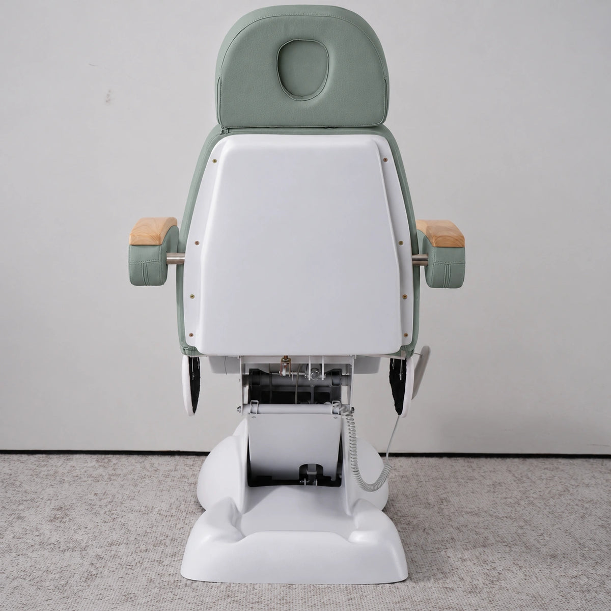 Rear view of the Manufakturo Grace Olive electric beauty bed, showing the upholstered headrest, white rigid rear cover and adjustment mechanism.