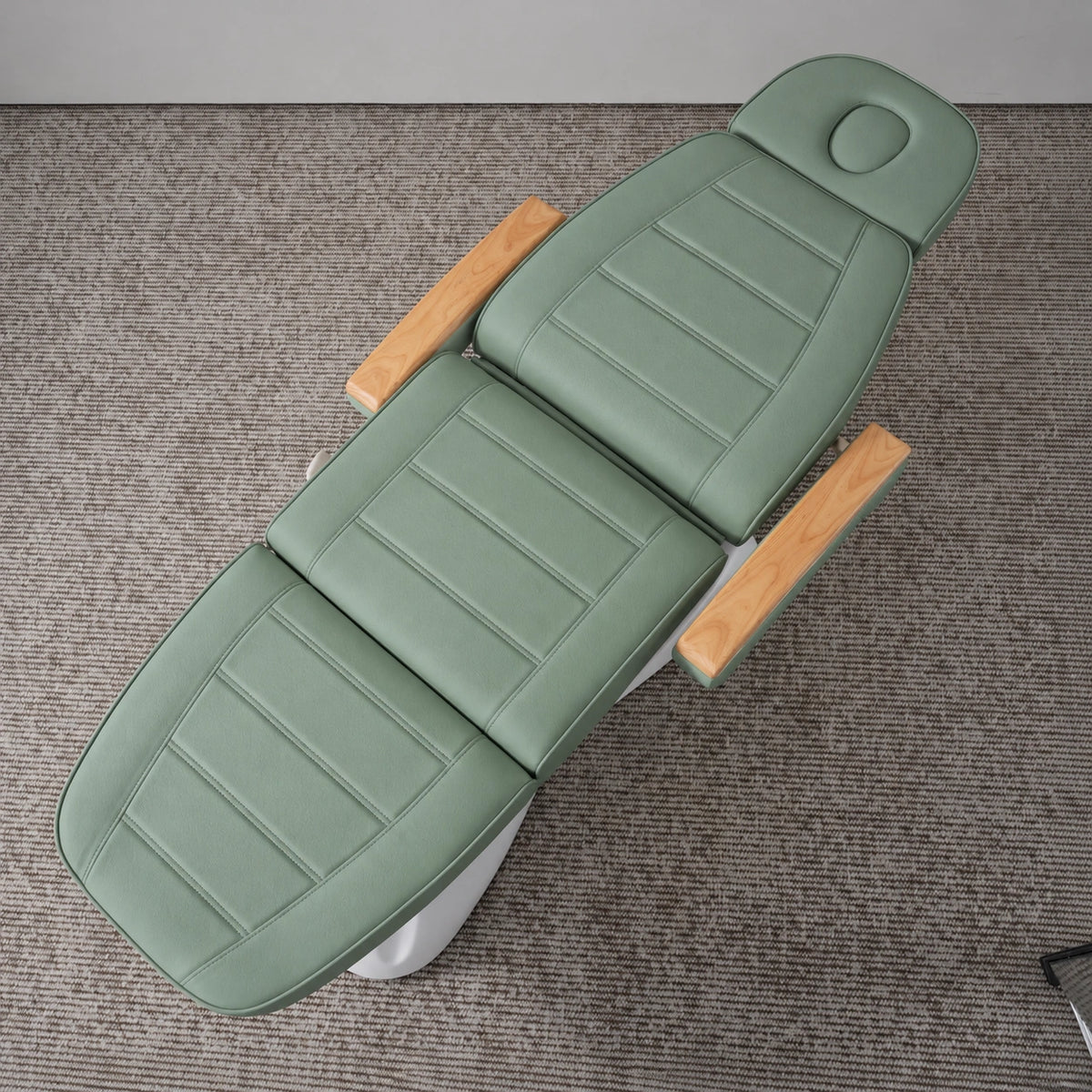 Manufakturo Grace Olive electric beauty bed viewed from above, showing the segmented upholstery, face insert and wooden armrest caps.