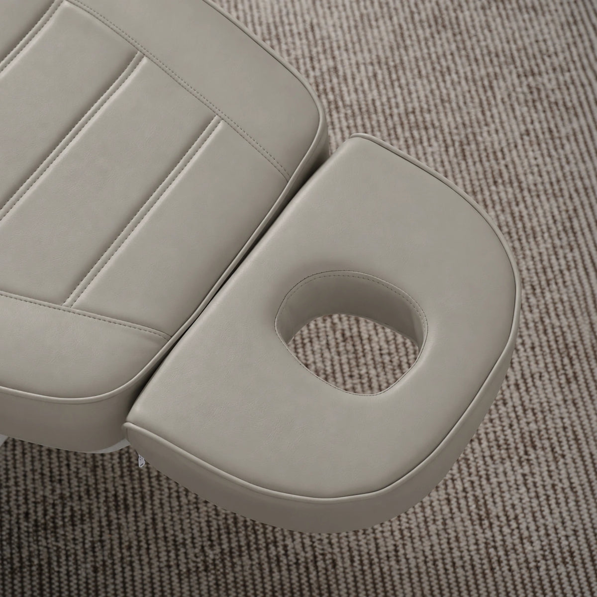Manufakturo Grace Pearl Greige electric beauty bed headrest detail, showing the open massage face hole and matching stitched upholstery.