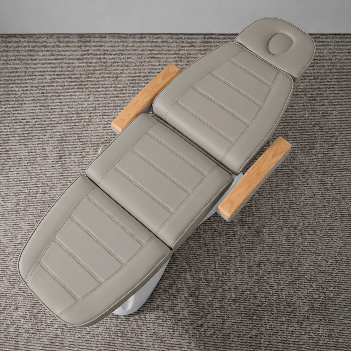Manufakturo Grace Pearl Greige electric beauty bed viewed from above, showing the segmented upholstery, face insert and wooden armrest caps.