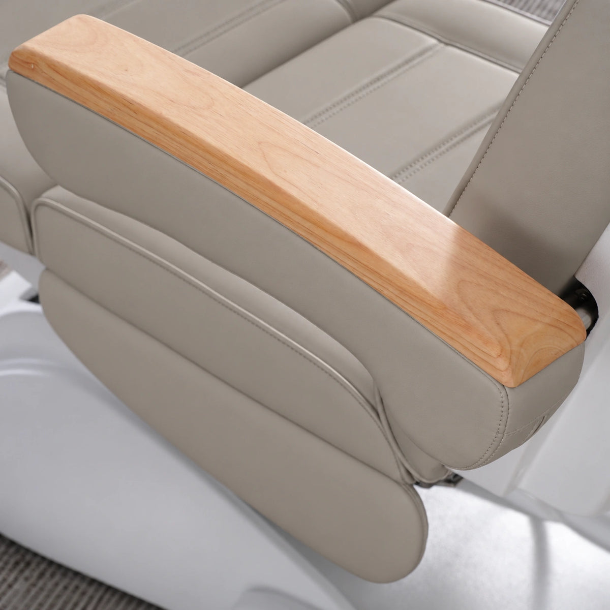 Manufakturo Grace Pearl Greige electric beauty bed armrest detail, showing the natural wooden top and matching upholstered side cushions.