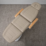 Manufakturo Grace Stone Taupe electric beauty bed viewed from above, showing the segmented upholstery, face insert and wooden armrest caps.