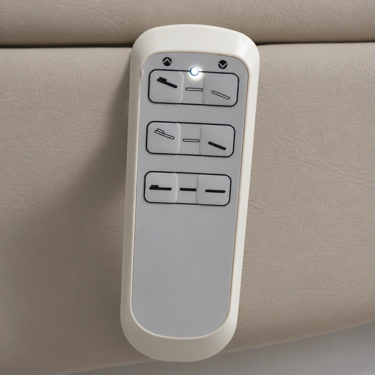 Manufakturo Grace Stone Taupe electric beauty bed hand-held control with the original buttons and indicator, against matching upholstery.