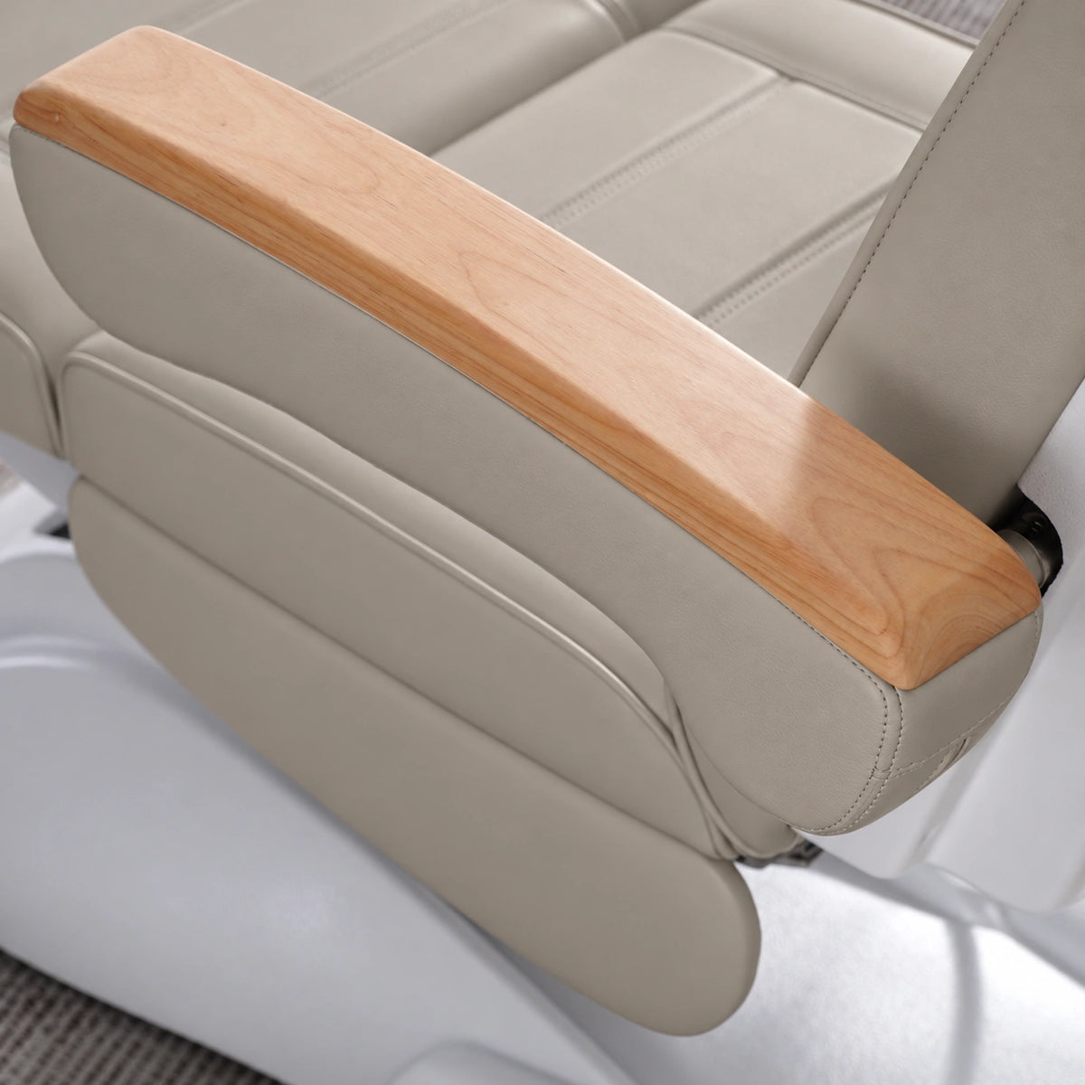 Manufakturo Grace Stone Taupe electric beauty bed armrest detail, showing the natural wooden top and matching upholstered side cushions.