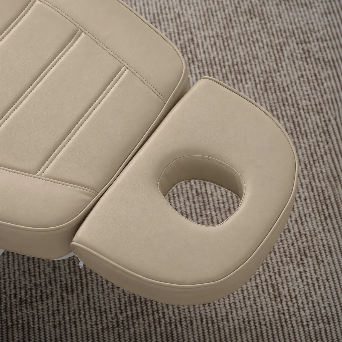 Manufakturo Grace Warm Beige electric beauty bed headrest detail, showing the open massage face hole and matching stitched upholstery.