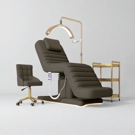 Manufakturo Grandeur Cocoa Mocha complete studio set with beauty bed, Noblesse chair, gold trolley and V3 Pro Gold treatment lamp, photographed against the original grey studio background.