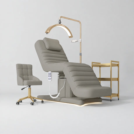 Manufakturo Grandeur Pearl Greige complete studio set with beauty bed, Noblesse chair, gold trolley and V3 Pro Gold treatment lamp, photographed against the original grey studio background.