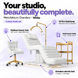 Manufakturo Grandeur White four-piece complete studio set: electric beauty bed with three motors and LED base, Noblesse swivel beauty chair, V3 Pro Gold adjustable treatment lamp and three-tier gold beauty trolley.