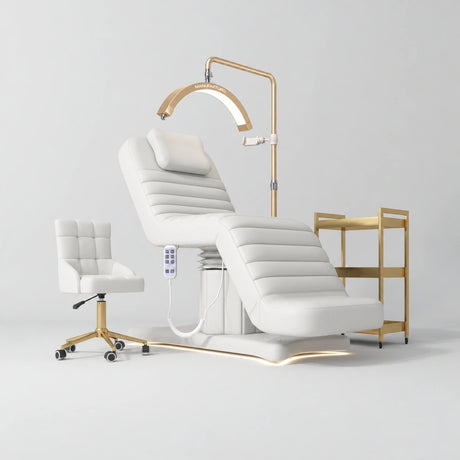 Manufakturo Grandeur White complete studio set with beauty bed, Noblesse chair, gold trolley and V3 Pro Gold treatment lamp, photographed against the original grey studio background.