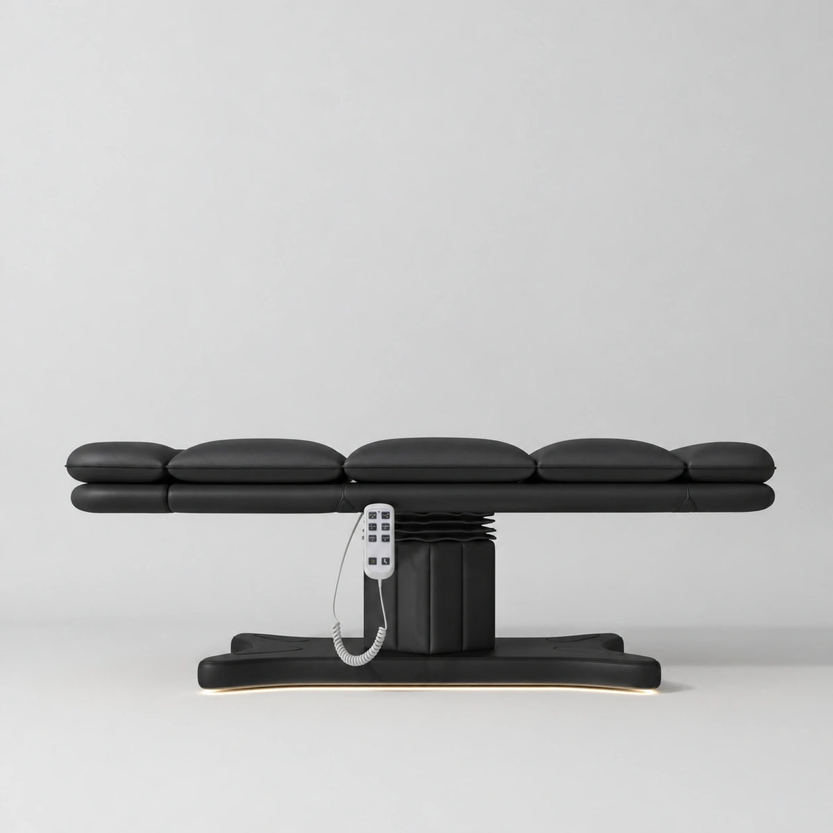 Manufakturo Imperial Signature heated electric beauty bed in Black, shown fully flat from the side with matching base and white remote control.