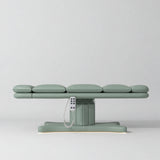 Manufakturo Imperial Signature heated electric beauty bed in Olive, shown fully flat from the side with matching base and white remote control.