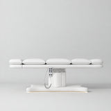 Manufakturo Imperial Signature White heated beauty bed fully flat in side view, showing smooth segmented upholstery, hand-held control and illuminated matching base.