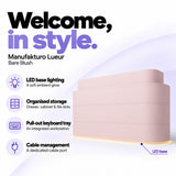 Manufakturo Lueur Bare Blush reception desk with LED base lighting, organised drawer, cabinet and file storage, a pull-out keyboard tray and dedicated cable port.