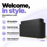 Manufakturo Lueur Black reception desk with LED base lighting, organised drawer, cabinet and file storage, a pull-out keyboard tray and dedicated cable port.