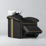 Manufakturo Monaco Black backwash unit with gold trim, white basin and extended electric leg rest, viewed from the front at an angle.