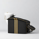 Manufakturo Monaco Black backwash unit with gold trim, white basin and extended electric leg rest, shown from a low side angle.