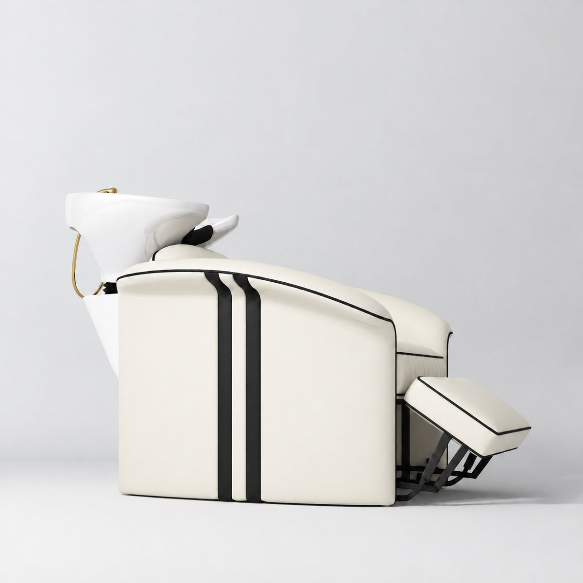 Manufakturo Monaco Creamy backwash unit with white basin and extended electric leg rest, shown from a low side angle.