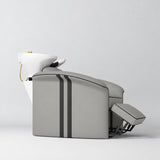 Manufakturo Monaco Pearl Greige backwash unit with white basin and extended electric leg rest, shown from a low side angle.