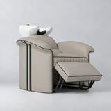 Manufakturo Monaco Stone Taupe backwash unit with white basin and extended electric leg rest, viewed from the front at an angle.