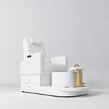 Manufakturo Noémie White electric pedicure chair with massage backrest, gold tap, empty ceramic basin and smooth white foot support.