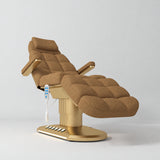 Manufakturo Orielle A Brown teddy electric beauty bed with gold oval base and current hand-held controller.