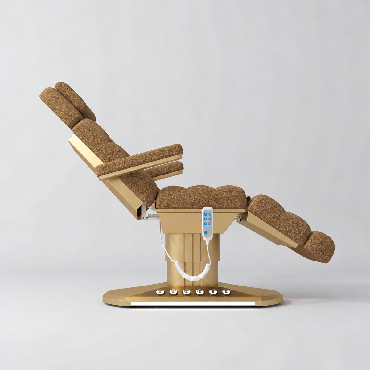 Manufakturo Orielle A Brown teddy electric beauty bed shown from the side in a treatment position, with gold oval base and hand-held controller.