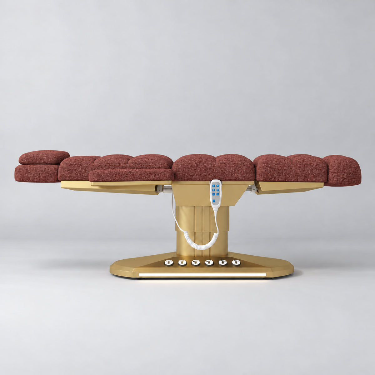 Manufakturo Orielle A Maroon teddy electric beauty bed in a flat position viewed from the side, with gold oval base and hand-held controller.
