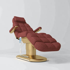 Manufakturo Orielle A Maroon teddy electric beauty bed with gold oval base and current hand-held controller.