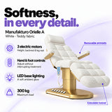 Manufakturo Orielle A White teddy electric beauty bed features: 3 motors, hand and foot controls, LED base lighting, 300 kg maximum load, removable armrests and extendable footrest.