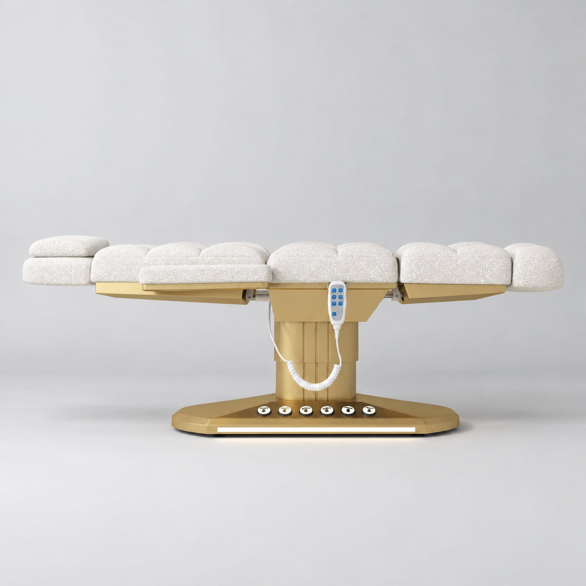 Manufakturo Orielle A White teddy electric beauty bed in a flat position viewed from the side, with gold oval base and hand-held controller.