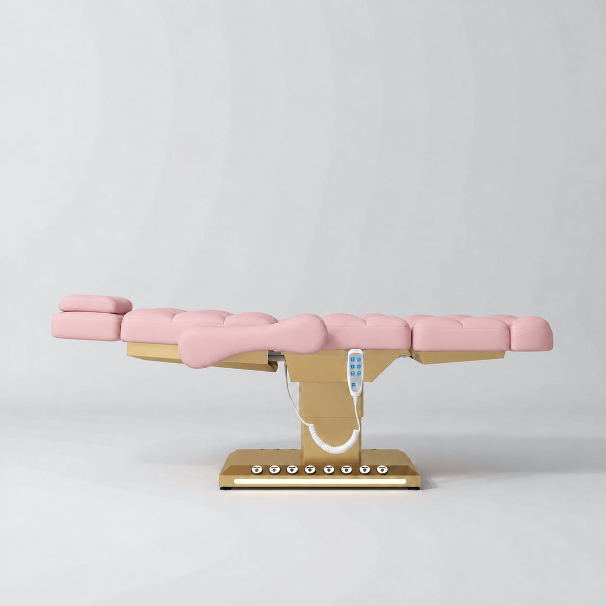 Manufakturo Orielle B Bare Blush electric beauty bed in a flat position viewed from the side, with gold base and hand-held controller.