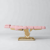 Manufakturo Orielle B Bare Blush electric beauty bed in a flat position viewed from the side, with gold base and hand-held controller.