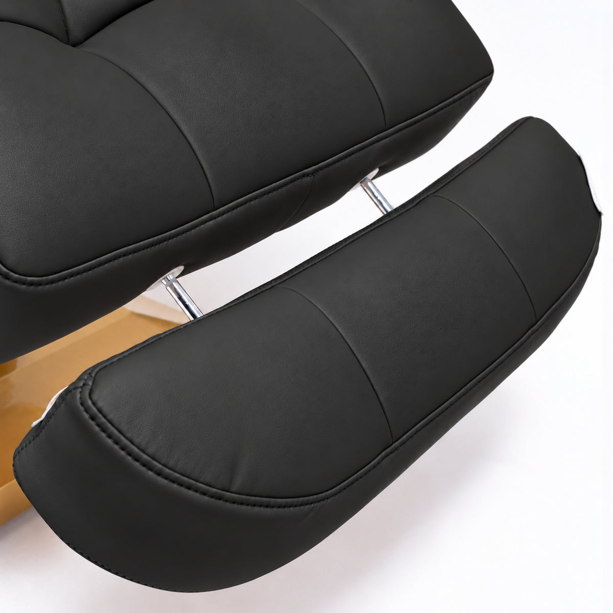 Manufakturo Orielle B Black extendable footrest showing faux-leather upholstery, stitching and chrome extension rods.