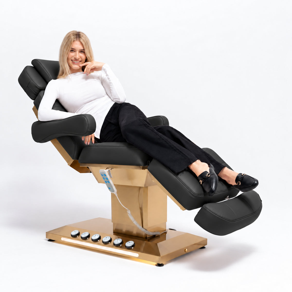 Manufakturo Orielle B Black beauty bed in use, showing upholstered armrests, extendable footrest, hand and foot controls and LED base lighting.