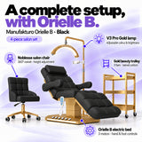 Manufakturo Orielle B Black four-piece salon set features: electric bed with three motors and hand and foot controls, height-adjustable Noblesse swivel chair, V3 Pro Gold lamp and three-tier gold trolley.