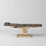 Manufakturo Orielle B Cocoa Mocha electric beauty bed in a flat position viewed from the side, with gold base and hand-held controller.