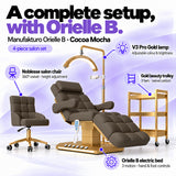 Manufakturo Orielle B Cocoa Mocha four-piece salon set features: electric bed with three motors and hand and foot controls, height-adjustable Noblesse swivel chair, V3 Pro Gold lamp and three-tier gold trolley.