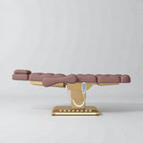Manufakturo Orielle B Dusty Rose electric beauty bed in a flat position viewed from the side, with gold base and hand-held controller.