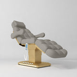 Manufakturo Orielle B Pearl Greige electric beauty bed with gold base and current hand-held controller.